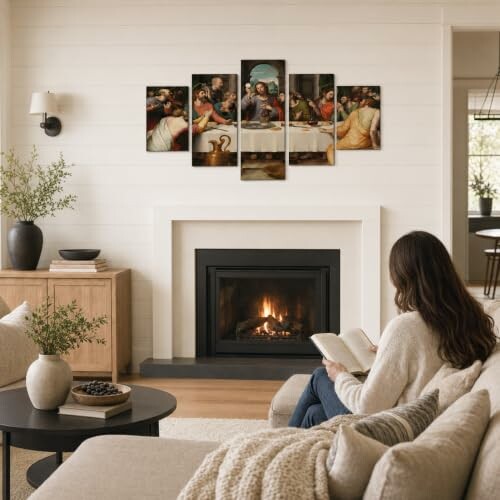 Woman reading in a cozy living room with a fireplace and artwork above.