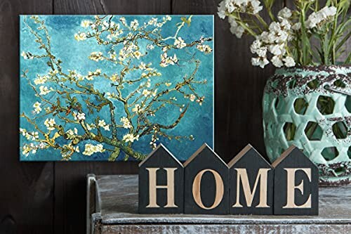 Decorative setup with a painting of blossoming branches, wooden 'HOME' letters, and a vase of flowers.