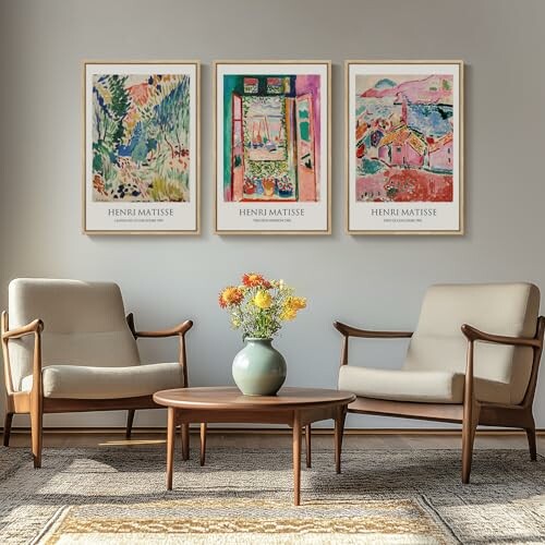 Living room with framed Henri Matisse artworks above chairs.