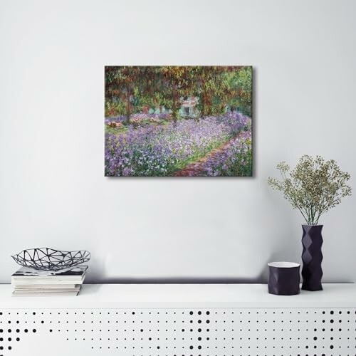 Painting of a garden scene on a white wall above a modern sideboard with books and vases.
